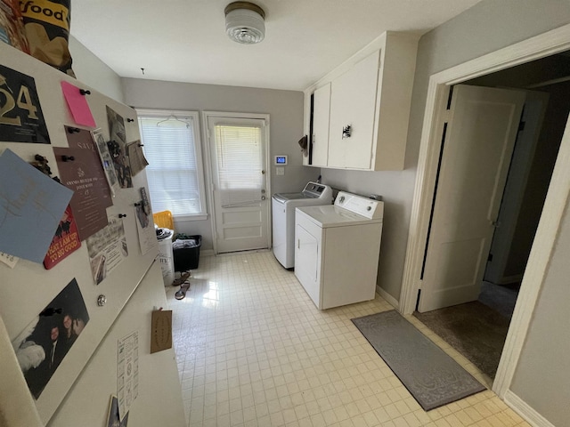 laundry room with washing machine and dryer and cabinets