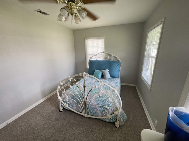 carpeted bedroom with multiple windows and ceiling fan