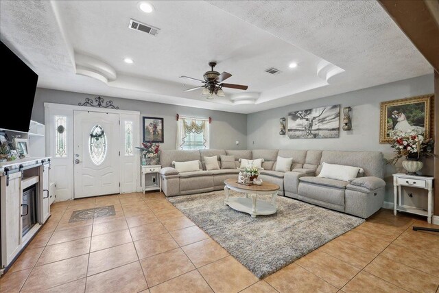 7645 Old Big Hill Rd, Beaumont, TX 77705 - living room featuring a raised ceiling, light tile patterned floors, a ceiling fan, recessed lighting, and a textured ceiling