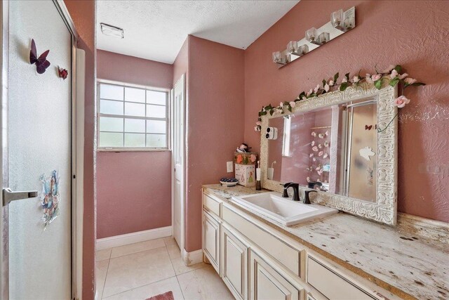 7645 Old Big Hill Rd, Beaumont, TX 77705 - full bath with a stall shower, vanity, tile patterned flooring, a textured ceiling, and baseboards