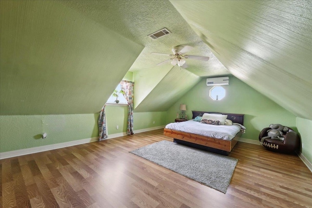 7645 Old Big Hill Rd, Beaumont, TX 77705 - bedroom featuring a wall unit AC, multiple windows, wood finished floors, and lofted ceiling