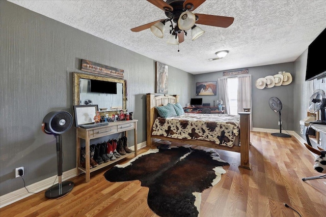 7645 Old Big Hill Rd, Beaumont, TX 77705 - bedroom featuring wood finished floors, baseboards, ceiling fan, and a textured ceiling