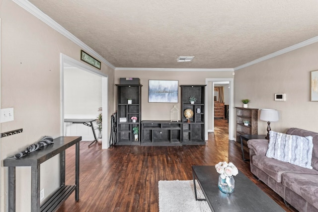 living room featuring visible vents, ornamental molding, a textured ceiling, and wood finished floors