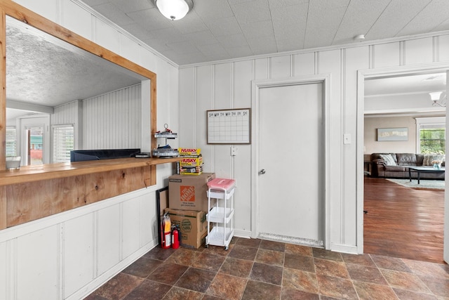 interior space with crown molding and stone finish flooring