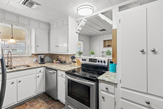 kitchen featuring visible vents, a sink, stainless steel appliances, white cabinets, and tasteful backsplash