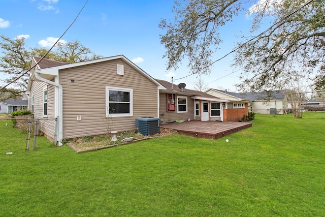 rear view of property featuring a yard, cooling unit, a deck, and fence