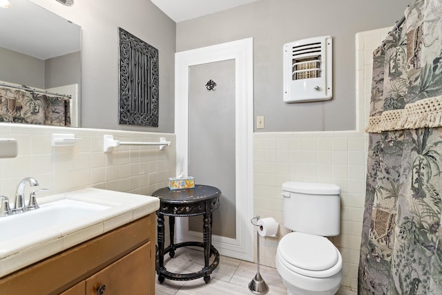 216 W Circuit Dr, Beaumont, TX 77706 - bathroom with tile walls, heating unit, toilet, wainscoting, and vanity