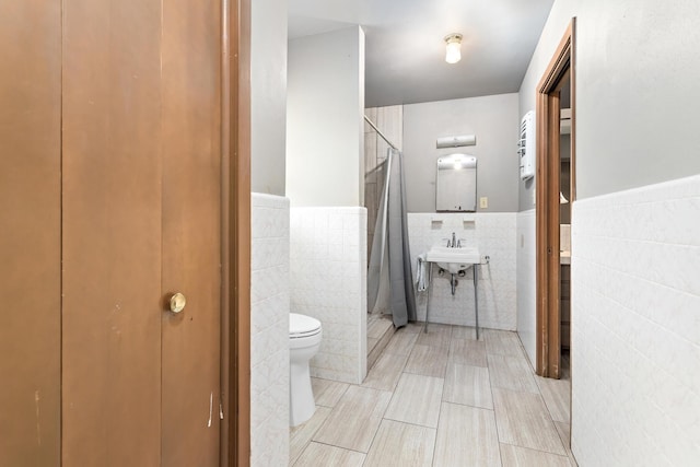 216 W Circuit Dr, Beaumont, TX 77706 - full bathroom with tile walls, toilet, a shower stall, a wainscoted wall, and a closet