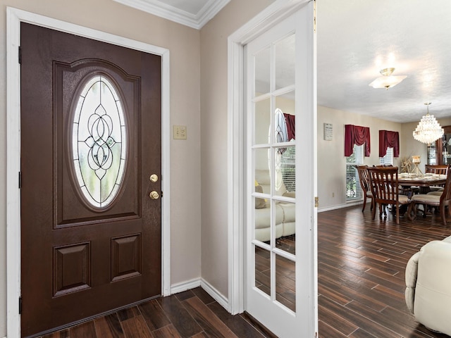 entrance foyer with crown molding and a chandelier