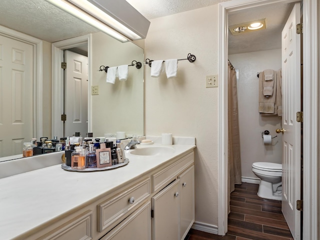 bathroom featuring a textured ceiling, vanity, and toilet