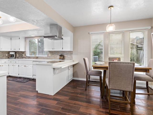 kitchen with kitchen peninsula, a healthy amount of sunlight, white cabinets, and pendant lighting