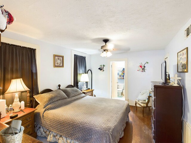 bedroom featuring ceiling fan, dark hardwood / wood-style flooring, a textured ceiling, and ensuite bath