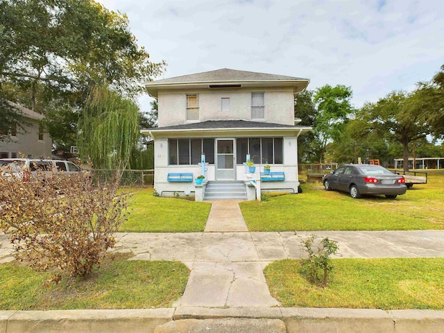 view of front of property featuring a sunroom and a front yard