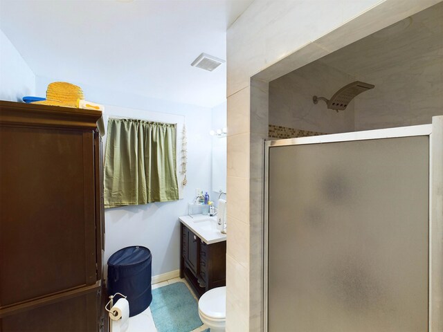 bathroom featuring tile patterned flooring, vanity, toilet, and walk in shower