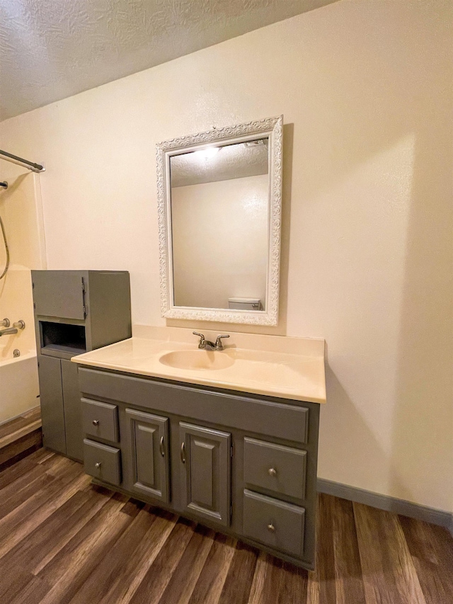 8140 Tx State Highway 62, Buna, TX 77612 - full bath featuring a textured ceiling, wood finished floors, and vanity