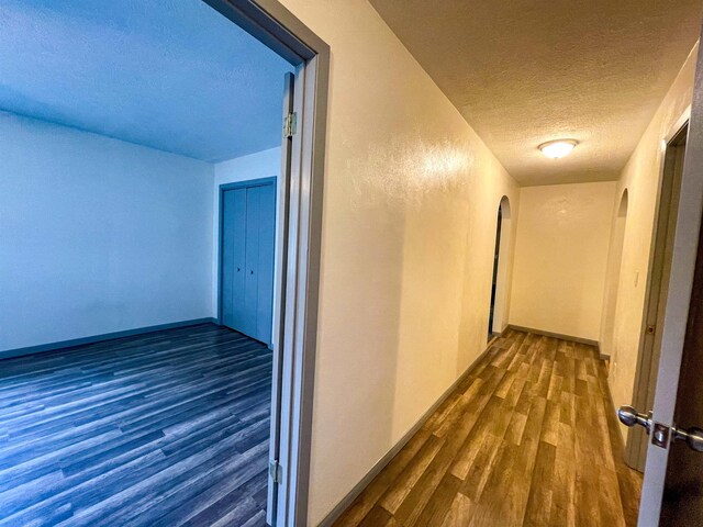 8140 Tx State Highway 62, Buna, TX 77612 - hall featuring arched walkways, a textured ceiling, and wood finished floors