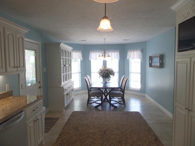 7035 Carroll Ln, Beaumont, TX 77713 - dining space with a chandelier, light tile patterned flooring, baseboards, and a textured ceiling