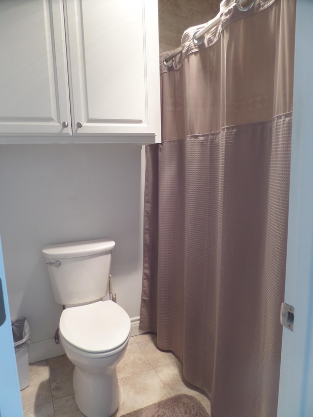 7035 Carroll Ln, Beaumont, TX 77713 - full bathroom featuring tile patterned floors, toilet, baseboards, and a shower with shower curtain