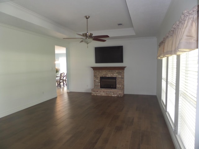 7035 Carroll Ln, Beaumont, TX 77713 - unfurnished living room with a raised ceiling, a ceiling fan, dark wood finished floors, a fireplace, and crown molding