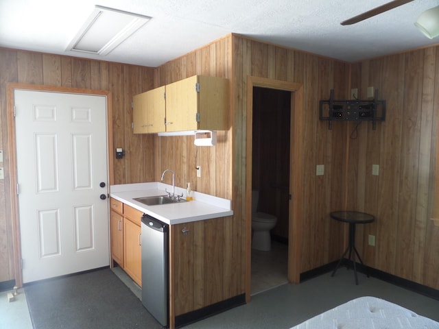 7035 Carroll Ln, Beaumont, TX 77713 - kitchen featuring a sink, dishwasher, light countertops, wood walls, and ceiling fan