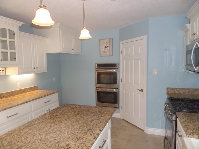 7035 Carroll Ln, Beaumont, TX 77713 - kitchen with appliances with stainless steel finishes, white cabinets, light stone countertops, and baseboards
