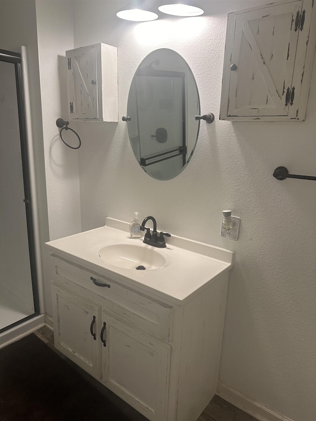 bathroom featuring a textured wall and vanity