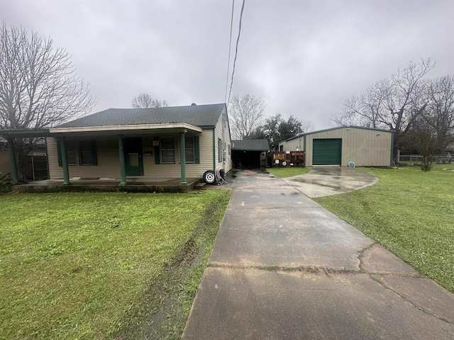 view of front of property with a garage, driveway, roof with shingles, an outdoor structure, and a front yard