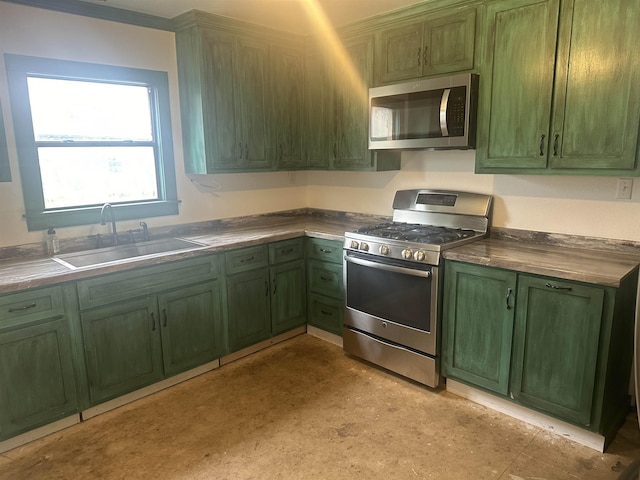 kitchen featuring appliances with stainless steel finishes, green cabinets, and a sink