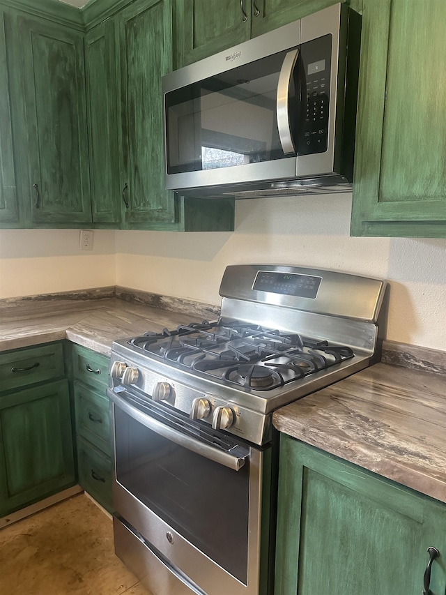 kitchen with appliances with stainless steel finishes and green cabinets