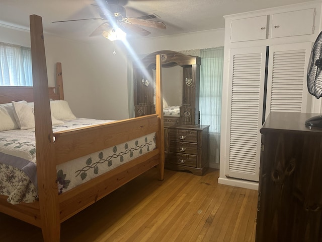 bedroom featuring light wood-style floors, a closet, visible vents, and ceiling fan