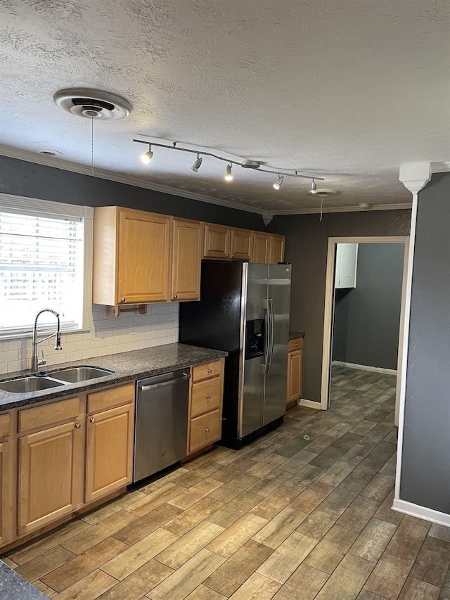 4715 Regina Ln, Beaumont, TX 77706 - kitchen featuring appliances with stainless steel finishes, backsplash, light wood finished floors, track lighting, and a textured ceiling