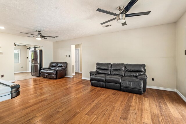 1385 Howell St, Beaumont, TX 77706 - living area with ceiling fan, wood finished floors, and a textured ceiling
