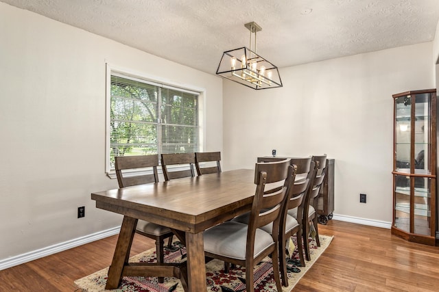 1385 Howell St, Beaumont, TX 77706 - dining room featuring wood finished floors, a textured ceiling, and a chandelier