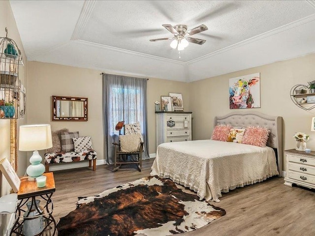 bedroom with a tray ceiling, ceiling fan, and crown molding