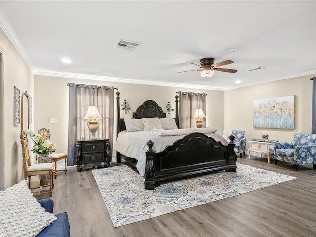 bedroom featuring ceiling fan, wood-type flooring, and ornamental molding