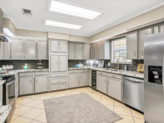 kitchen featuring gray cabinetry, sink, wine cooler, light tile patterned flooring, and appliances with stainless steel finishes