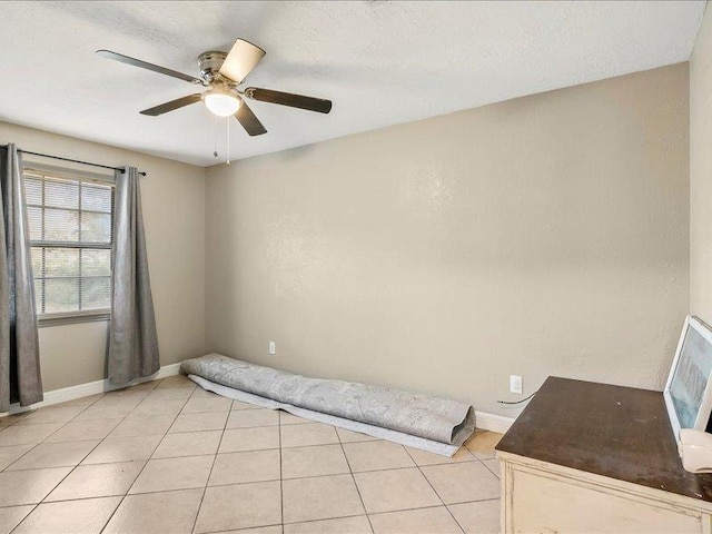 empty room with ceiling fan and light tile patterned flooring