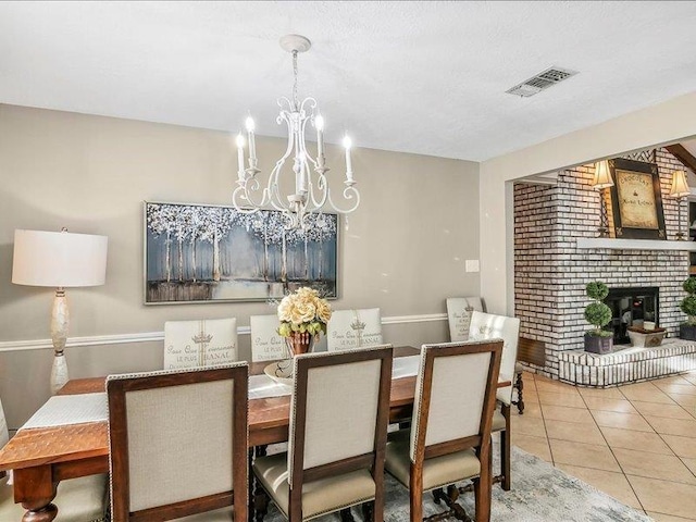 dining space featuring a chandelier, light tile patterned floors, and a fireplace