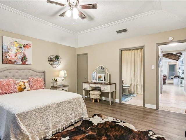 bedroom featuring ceiling fan, light wood-type flooring, a textured ceiling, and ornamental molding