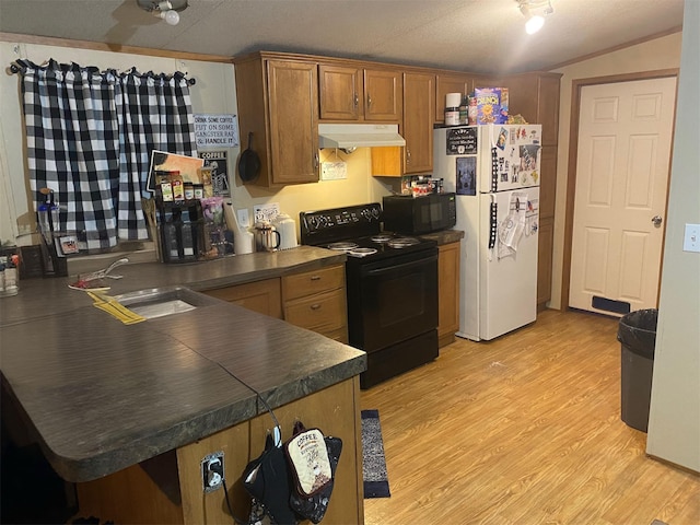 kitchen with under cabinet range hood, black appliances, dark countertops, a sink, and a peninsula