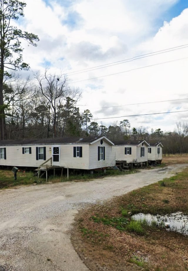 manufactured / mobile home with dirt driveway