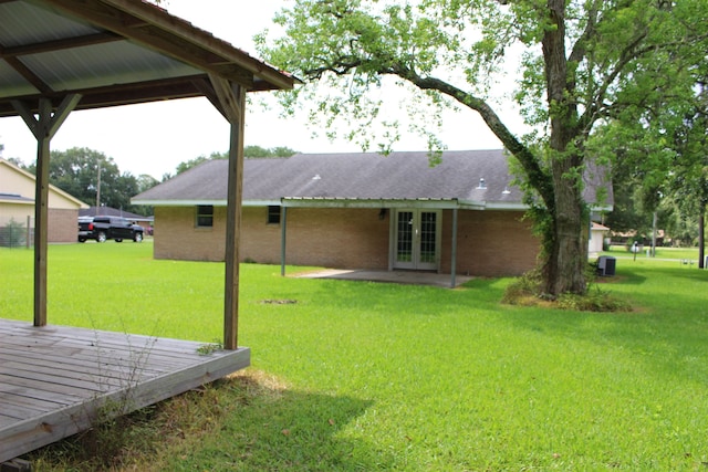 619 Carolyn St, Winnie, TX 77665 - view of grassy yard featuring french doors and a deck