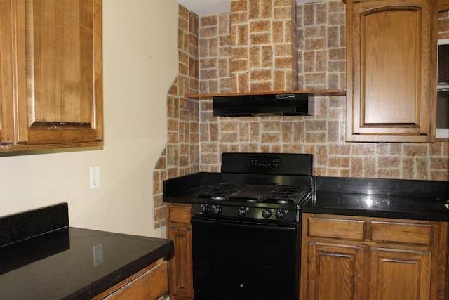 619 Carolyn St, Winnie, TX 77665 - kitchen with black gas range, under cabinet range hood, backsplash, dark countertops, and brown cabinets