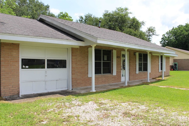 619 Carolyn St, Winnie, TX 77665 - ranch-style house featuring brick siding, a front yard, roof with shingles, and covered porch