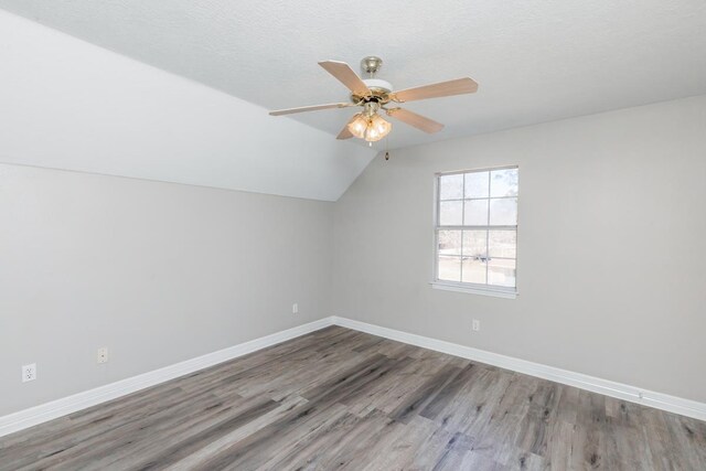 additional living space with a textured ceiling, ceiling fan, lofted ceiling, and hardwood / wood-style flooring