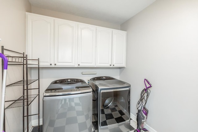 washroom featuring cabinets and washer and clothes dryer