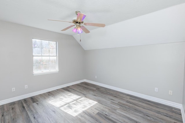 additional living space featuring hardwood / wood-style floors, vaulted ceiling, and ceiling fan