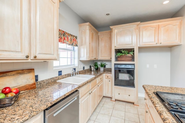 kitchen with sink, gas cooktop, light stone counters, stainless steel dishwasher, and black oven