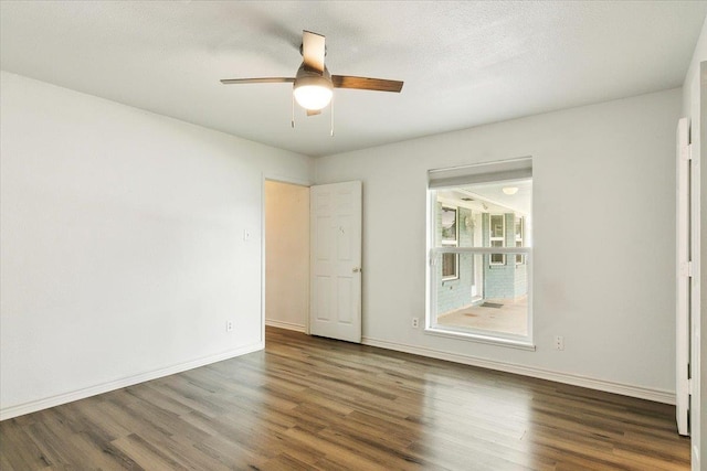 spare room featuring dark hardwood / wood-style floors and ceiling fan