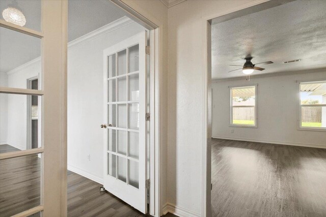 interior space featuring a textured ceiling, dark hardwood / wood-style flooring, and ornamental molding